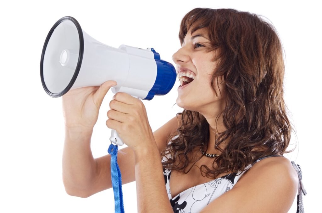 Girl speaking aloud using megaphones to reach her goal